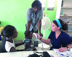 Lauryn Onstead, a member of Jefferson Baptist Church in Baton Rouge, takes this little girl’s temperature as the parents look on at the medical clinic that was part of a mission trip to Haiti.