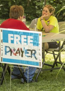 Julie DuVall of First Baptist Church in Bolivar, Mo., takes time to listen to prayer requests from a young man during a block party hosted by Canaan Baptist Church in Imperial, Mo., on Saturday, June 11. The block party was part of Crossover St. Louis 2016, held prior to the annual meeting of the Southern Baptist Convention June 14-15 at America's Center in St. Louis. Chris Carter