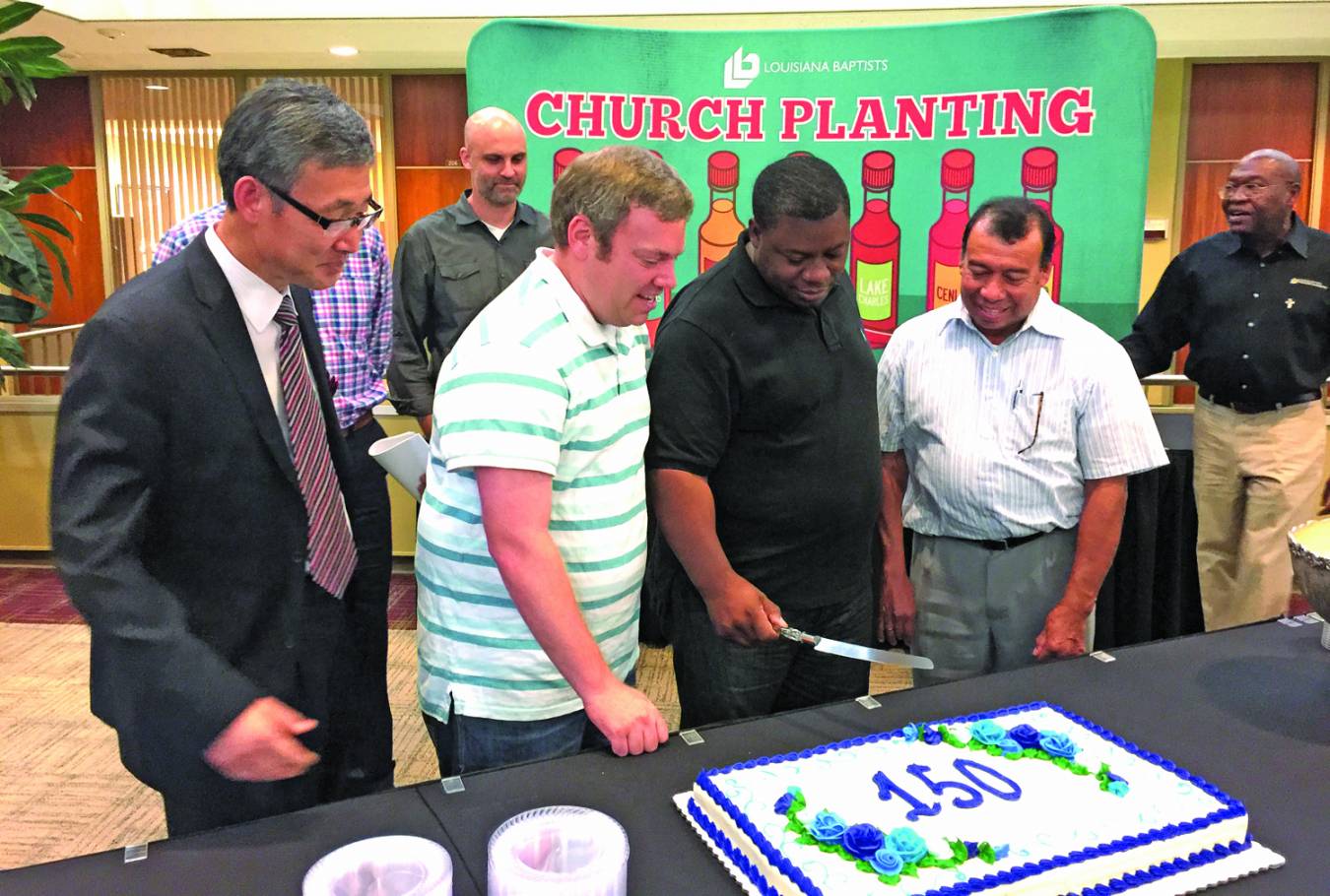 David Lee, pastor of Bansuk Korean Baptist Church in Bossier City; Jacob Crawford, pastor of Life Point Church in Mansura; James Riley, pastor of House of Prayer in Baton Rouge; and Cleto Perez, pastor of Nueva Vida Baptist Church in Athens, prepare to cut a cake commemorating the 150th Louisiana Baptist church planted since 2010.