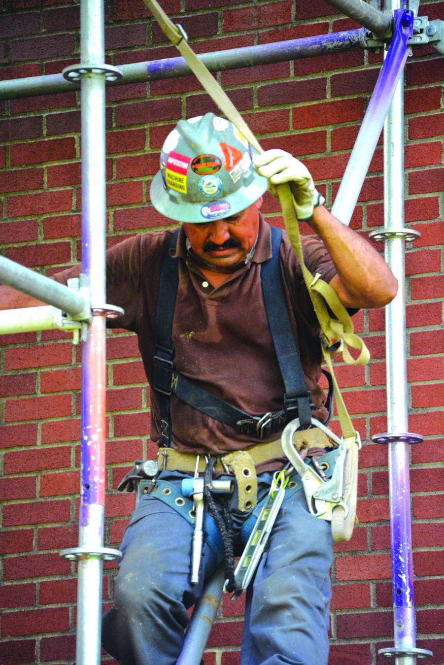 A construction worker looks down toward the sidewalk surrounding Guinn Auditorium. The work is part of ongoing campus improvement projects at Louisiana College.