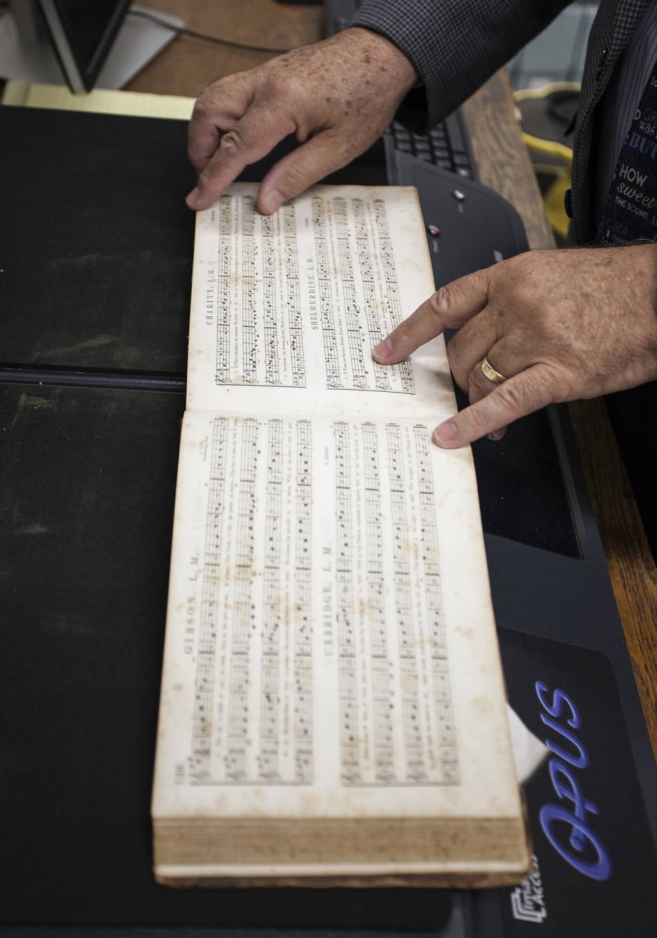 Leavell College professor Ed Steele prepares an early "tune book" for scanning. Tune books, which appeared in the 1830s, were among the first books to include music notes. Earlier hymnals included only the text of the hymn