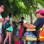 Ally Spring (left) and Carly Moore (second from left), students at LSU, distribute advertising a medical clinic held later in the day.