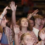 Students lift their hands in praise during a time of worship at the Tomorrow's Hope GO TELL Crusade. Doug Collier photo