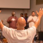 An inmate at the Louisiana State Penitentiary at Angola lifted his hands toward heaven during a time of worship at a revival on the prison grounds September 19.