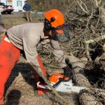 A member of First Baptist Church in Haughton used a chainsaw to help clear debris scattered across a home in the community.